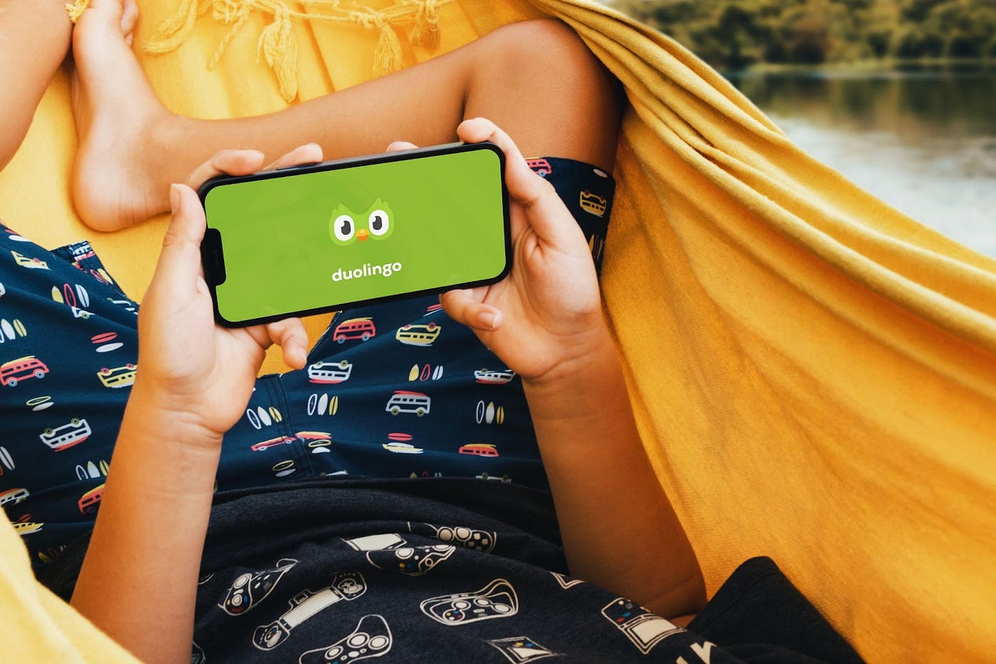A person relaxing in a hammock, holding a phone