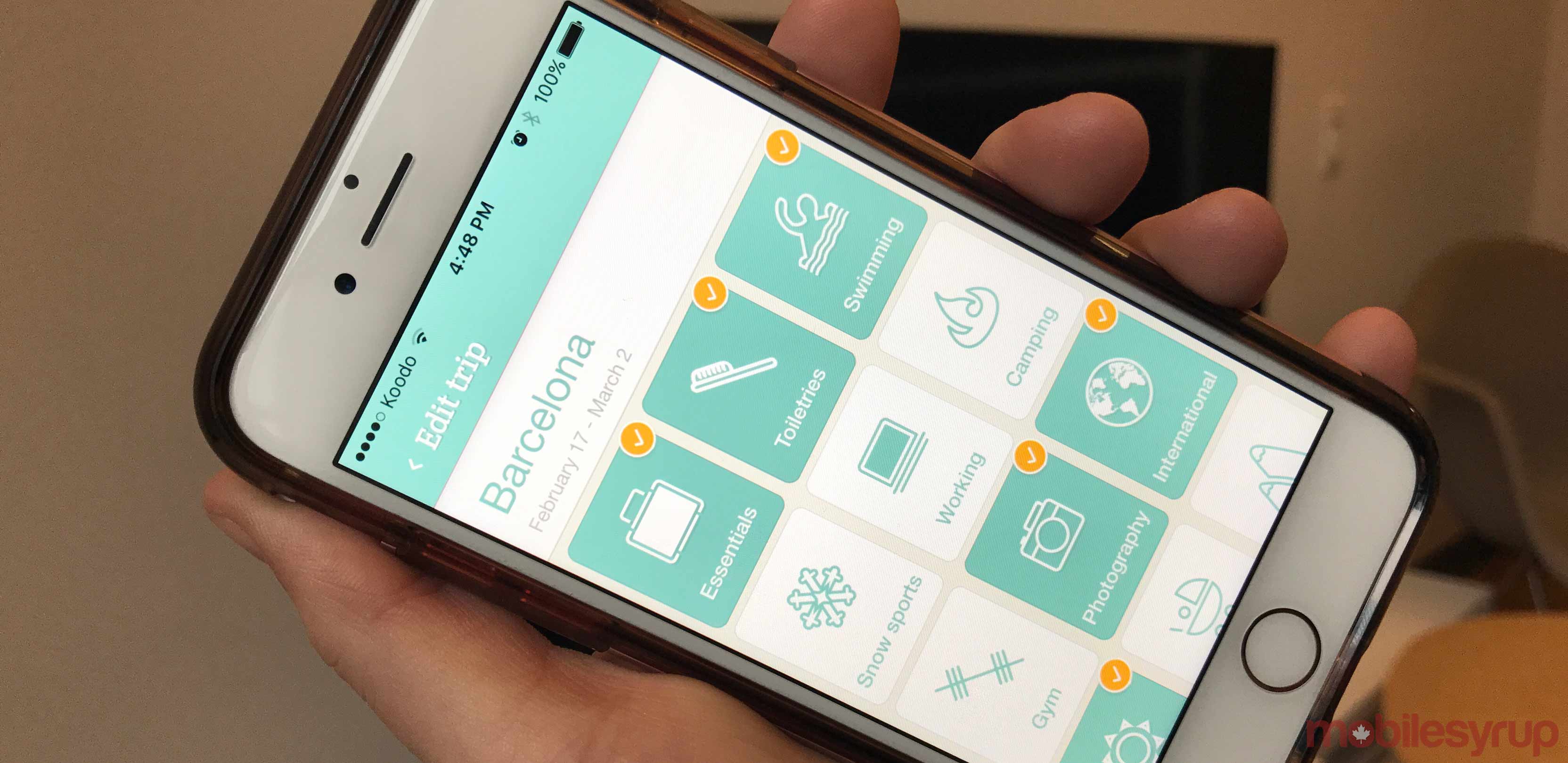 A person holding an iPhone displaying an app on the screen