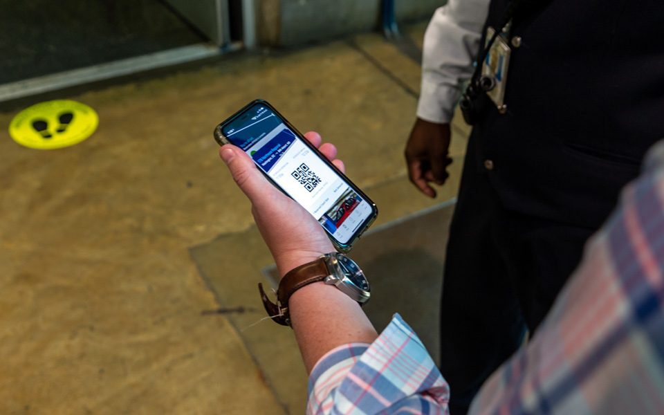 A person holding a cell phone displaying a QR code