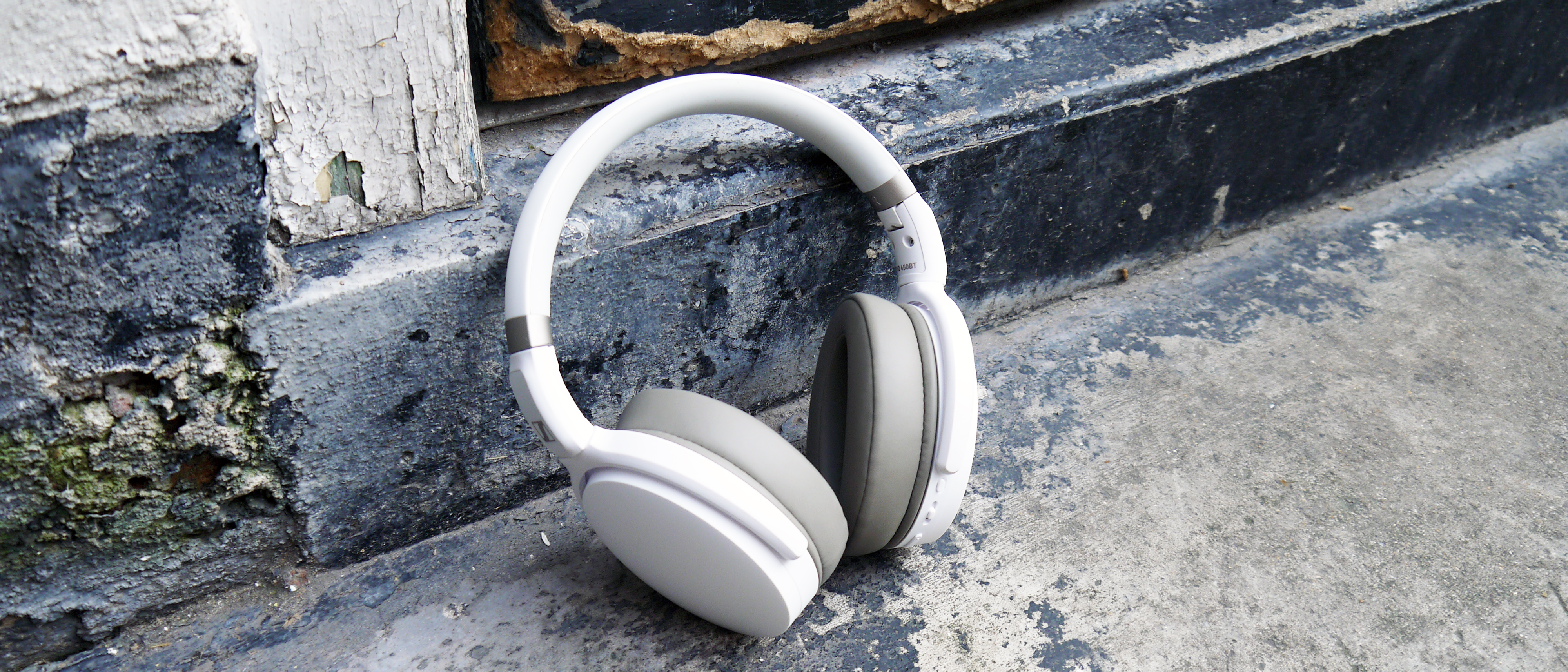 Sennheiser HD 450BT rests on a textured concrete wall